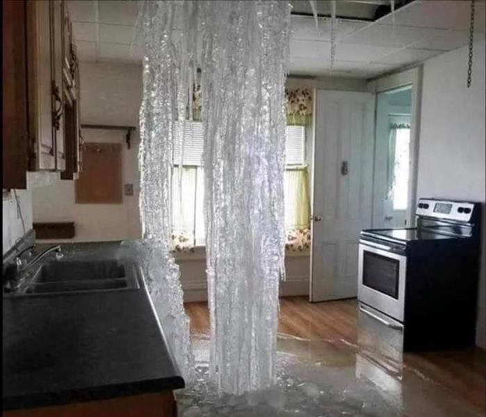 Water falling in a home kitchen and it's now a frozen water fall connecting the roof and the floor